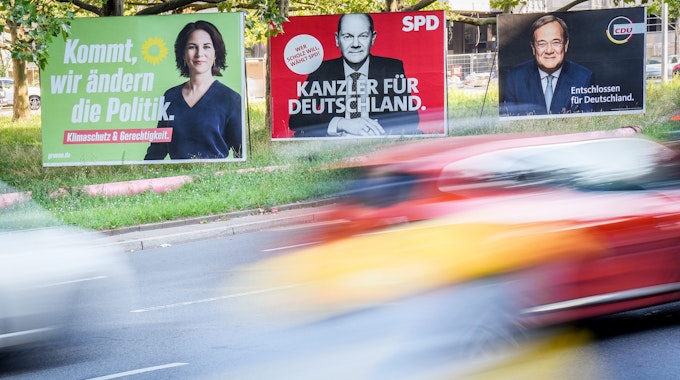 Berlin: Autos fahren an Wahlplakaten von Bündnis 90/Die Grünen, SPD und CDU vorbei.
