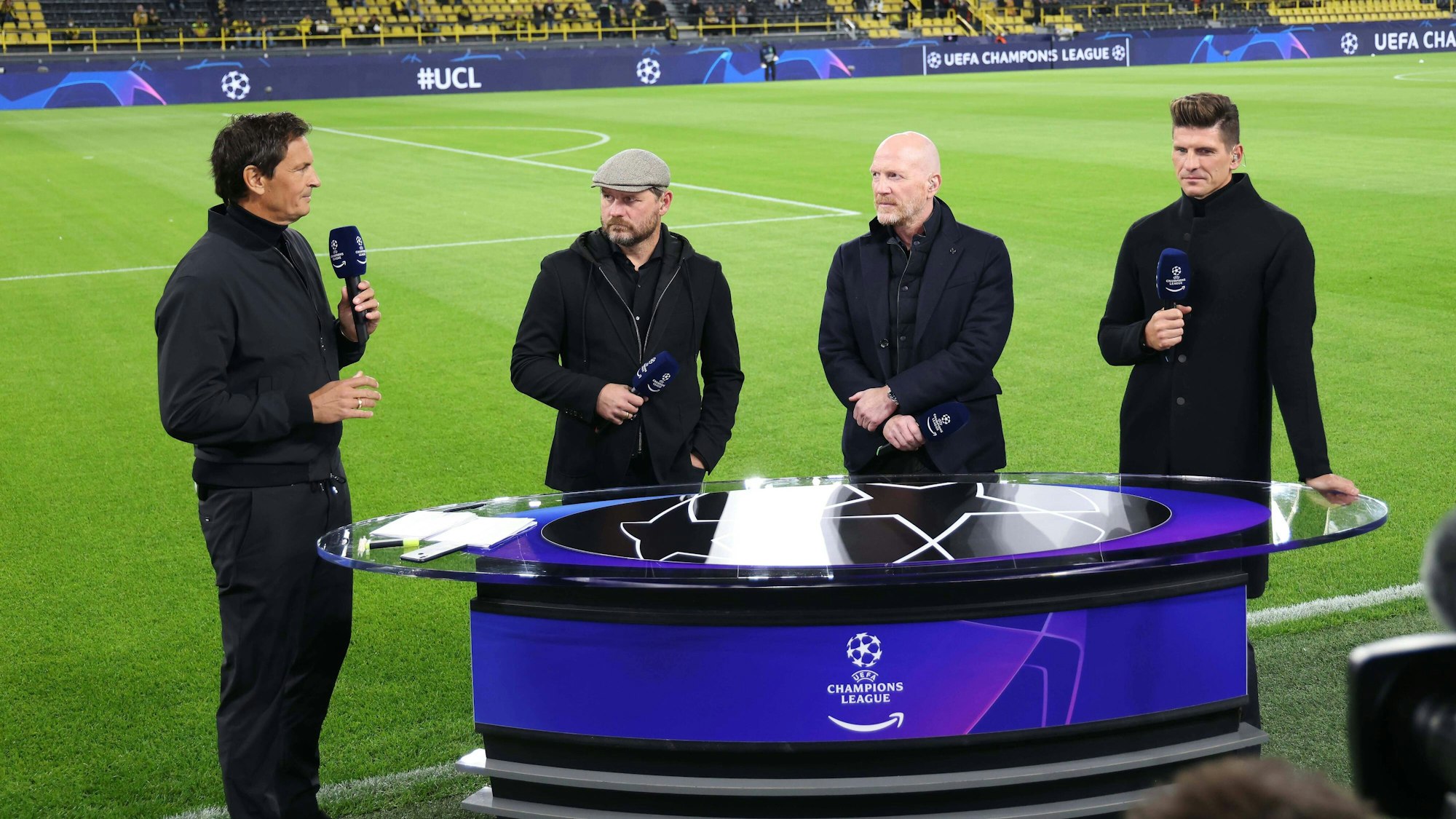 Sebastian Hellmann diskutiert mit Steffen Baumgart, Matthias Sammer und Mario Gomez vor dem Spiel in Dortmund.