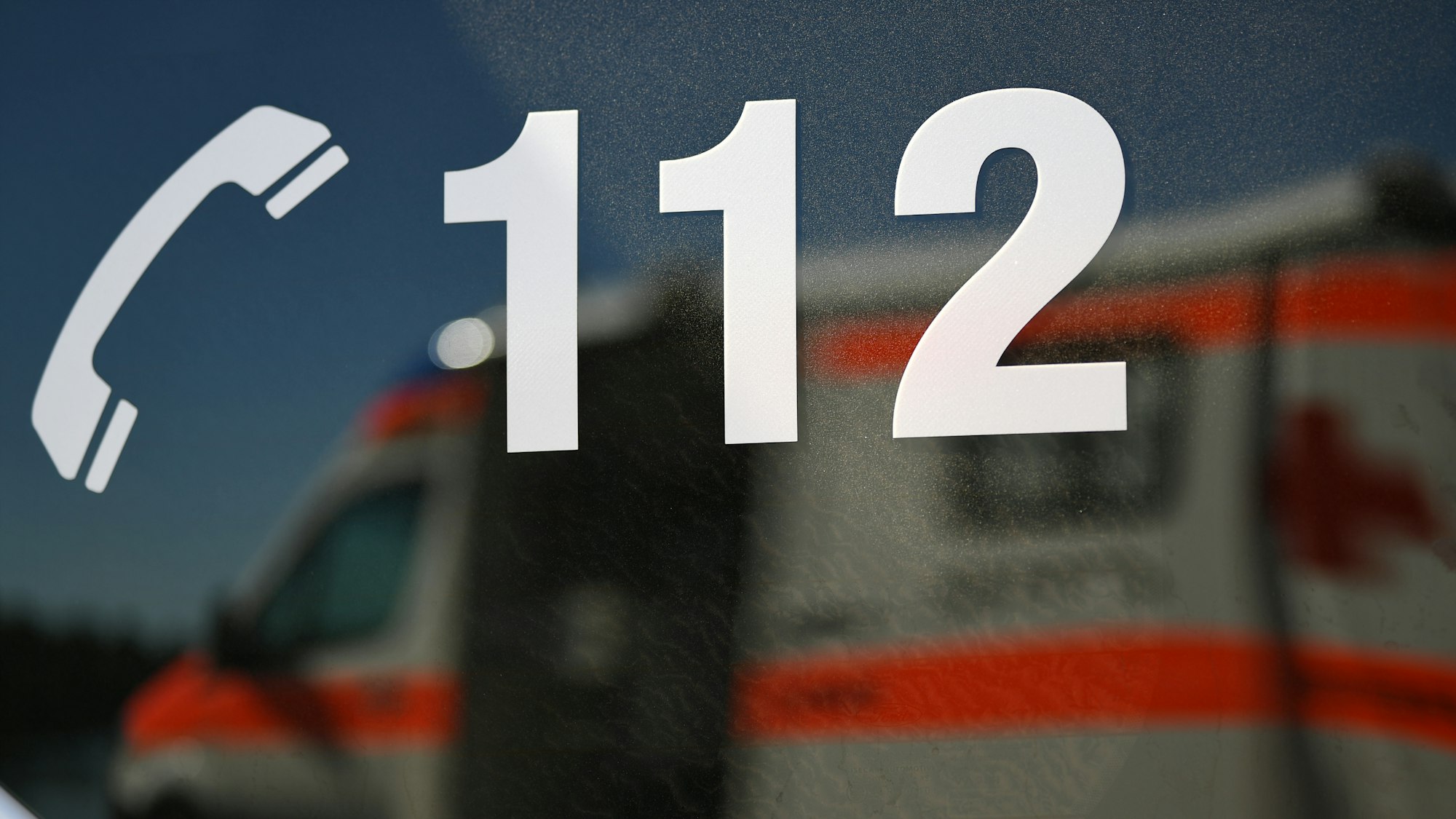 Ein Rettungswagen spiegelt während einer Übung in einem Fenster eines anderen Rettungswagen mit der Aufschrift "112".
