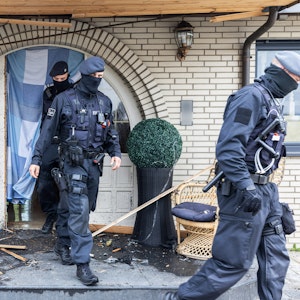 Polizisten verlassen die Leverkusener Villa nach der Razzia.