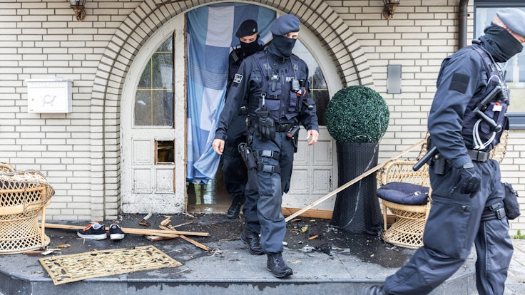 Polizisten verlassen die Leverkusener Villa nach der Razzia.