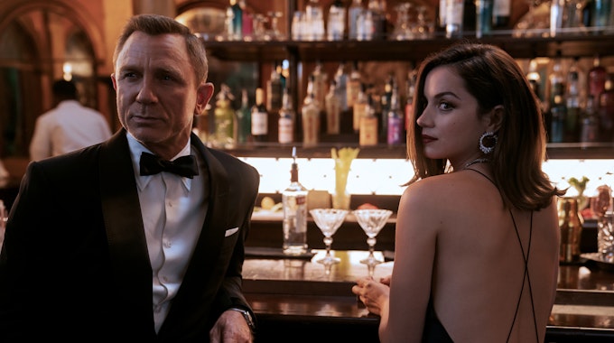 Daniel Craig als James Bond und Ana de Armas als Agentin Paloma stehen in einer Szene des Films „James Bond 007 - Keine Zeit zu sterben“ an einer Bar.