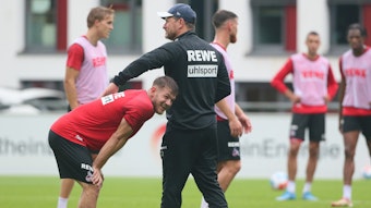 Steffen Baumgart scherzt mit Jan Thielmann beim Training des 1. FC Köln.