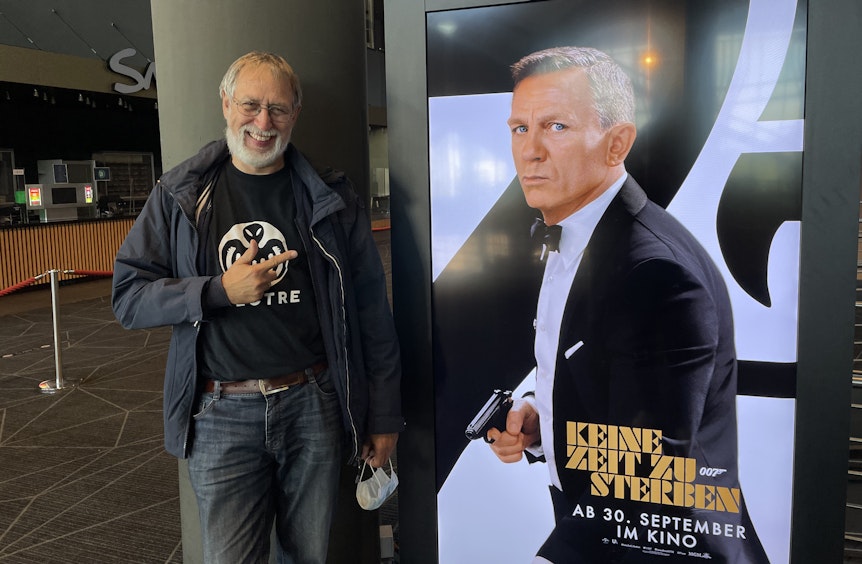 Bond-Fan Wolfgang Weber neben einer Werbetafel für den neuen James Bond-Film.