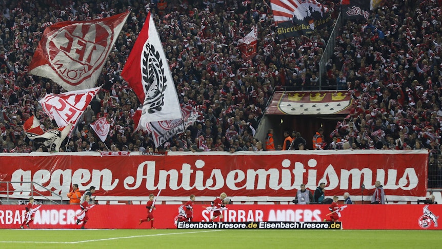 Vor der Kölner Südkurve im Rhein-Energie-Stadion hängt ein großes Banner gegen Antisemitismus.