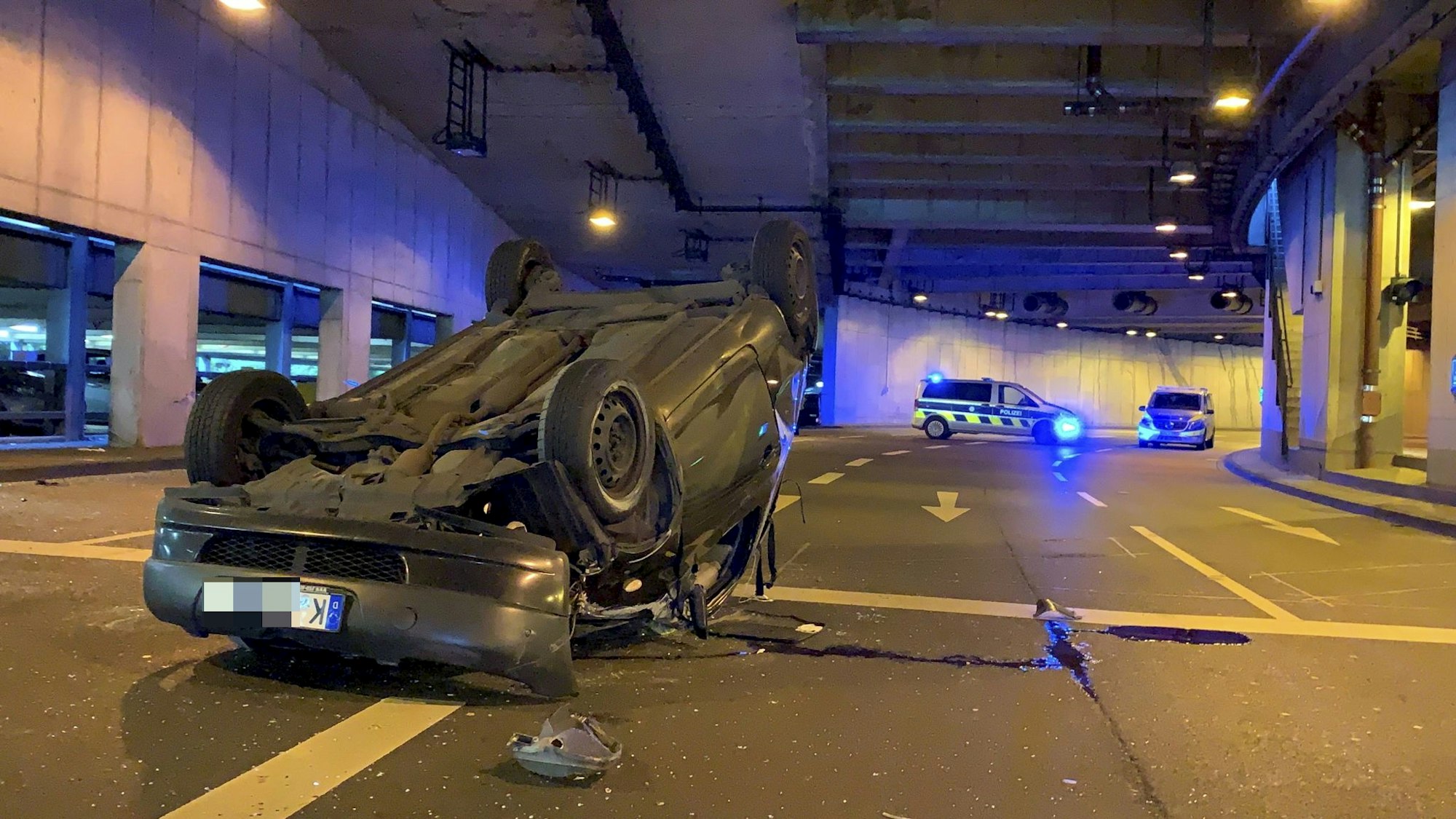 Ein Auto liegt im Tunnel der Lanxess Arena auf dem Dach.