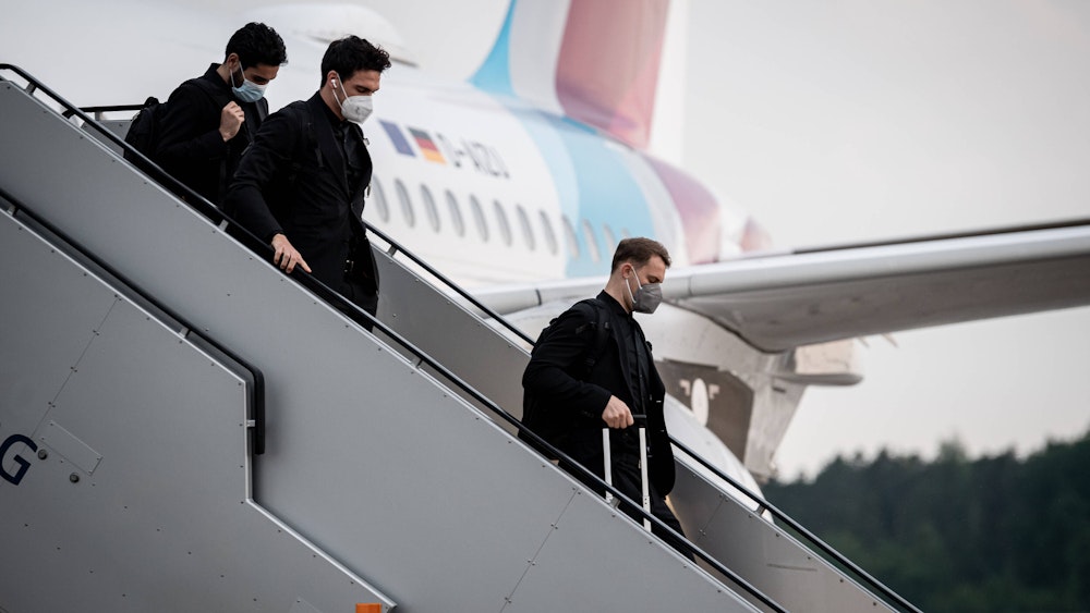Manuel Neuer, Mats Hummels und Ilkay Gündogan gehen die Treppe am Flugzeug herunter.