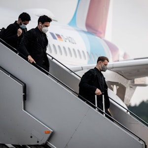 Manuel Neuer, Mats Hummels und Ilkay Gündogan gehen die Treppe am Flugzeug herunter.