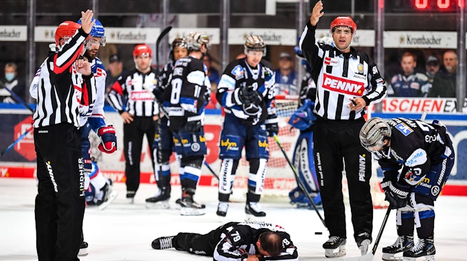 Linienrichter Andreas Kowert liegt nach einem Zusammenprall auf dem Eis.