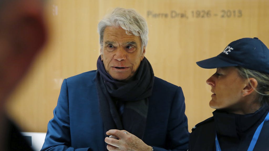 Bernard Tapie (l.), früherer Adidas-Eigner sowie Minister, Schauspieler und Fußballmanager, kommt in Begleitung einer Polizistin an einem Pariser Gericht an.