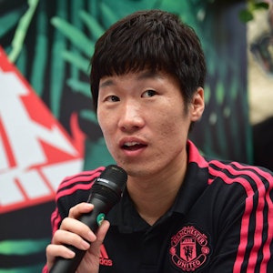 Ji-sung Park spricht in ein Mikrofon und trägt ein schwarz-rotes Shirt von Manchester-United.