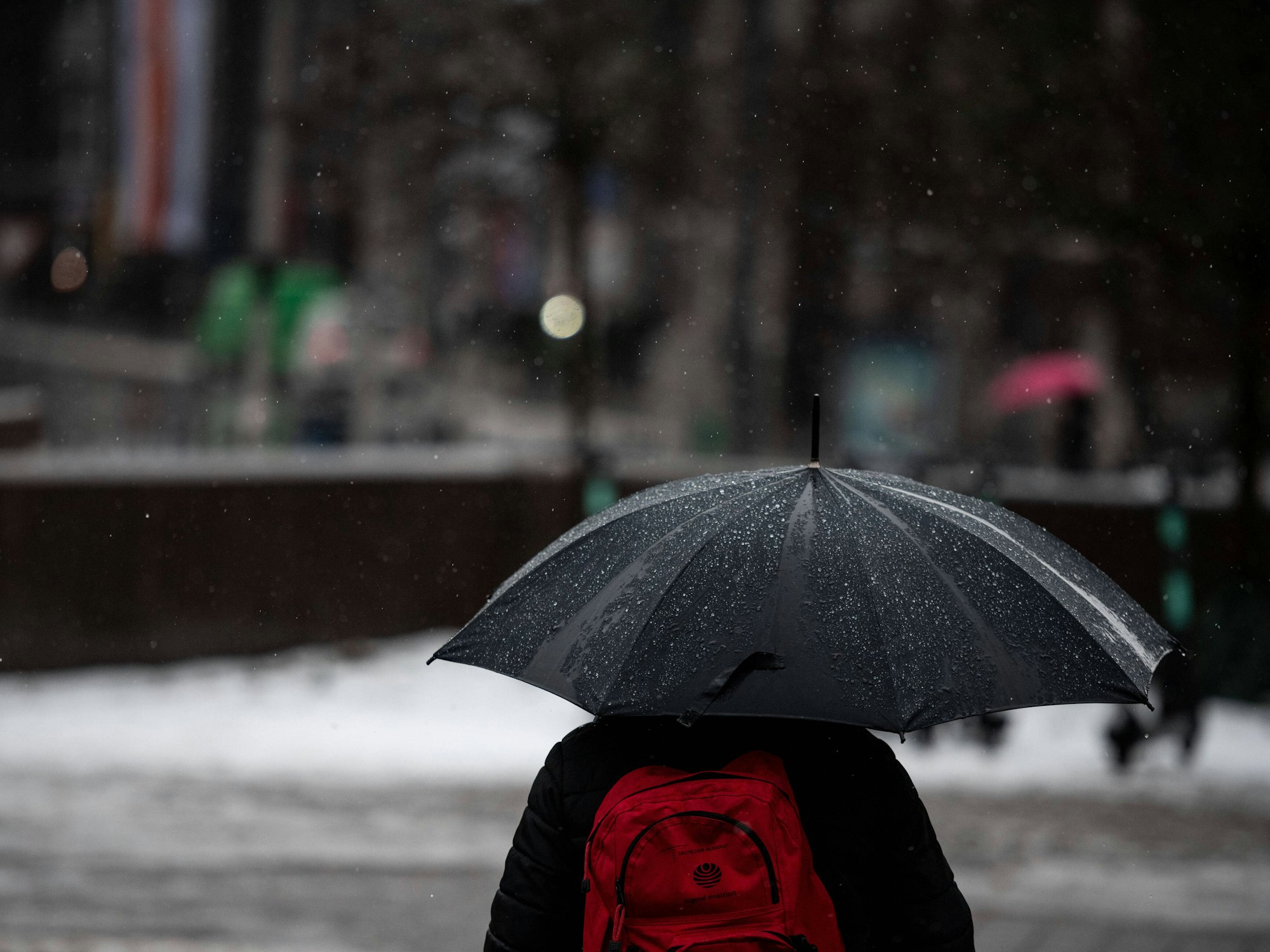 Düsseldorf: Ein Mann läuft mit Regenschirm durch den Regen in der Düsseldorfer Innenstadt.
