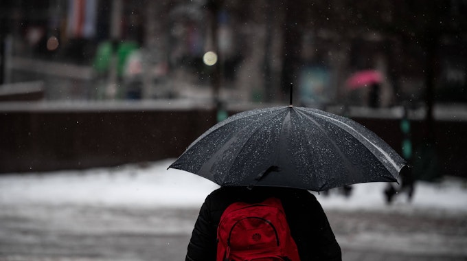 Düsseldorf: Ein Mann läuft mit Regenschirm durch den Regen in der Düsseldorfer Innenstadt.&nbsp;