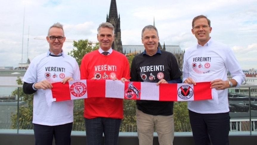 Die drei Geschäftsführer vom 1. FC Köln, Fortuna Köln und Viktoria Köln präsentieren den Turnierschal.