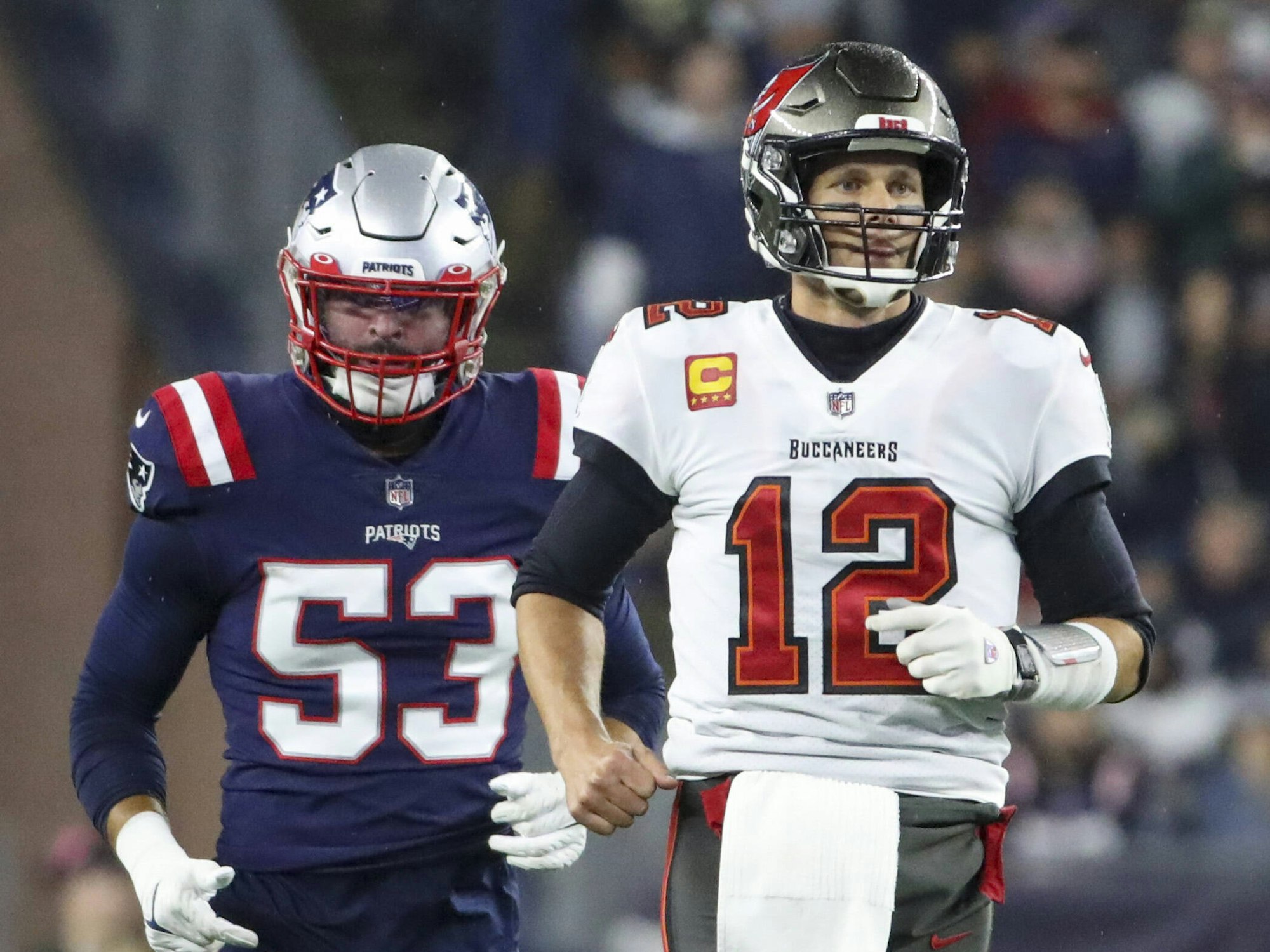 In voller Football-Montur stehen Kyle Van Noy von den Patriots und Tom Brady von den Buccaneers nebeneinander
