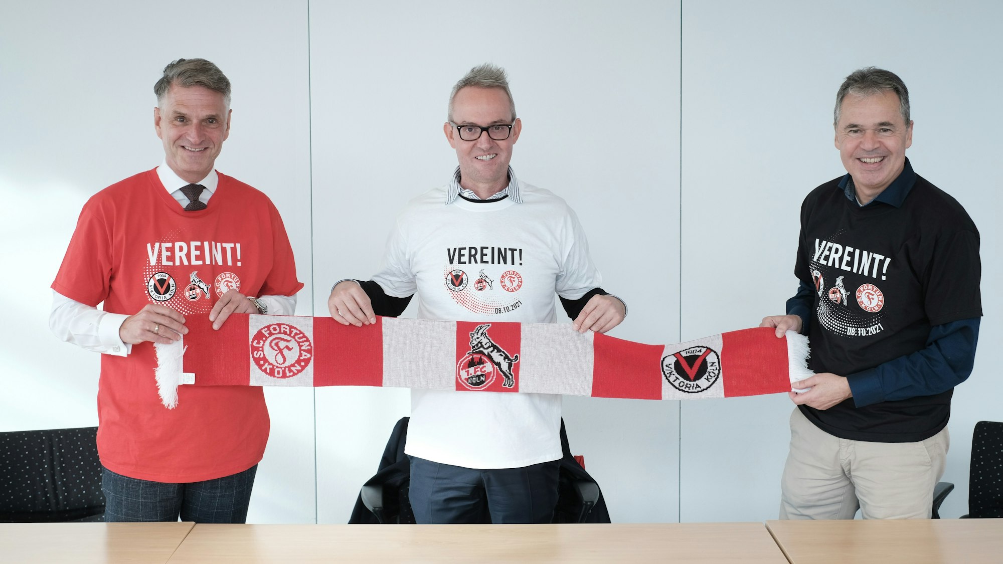 Andreas Rettig, Alexander Wehrle und Hanns-Jörg Westendorf (v.r.) demonstrieren gemeinsam mit dem „Mottoschal“ und T-Shirt Einigkeit.