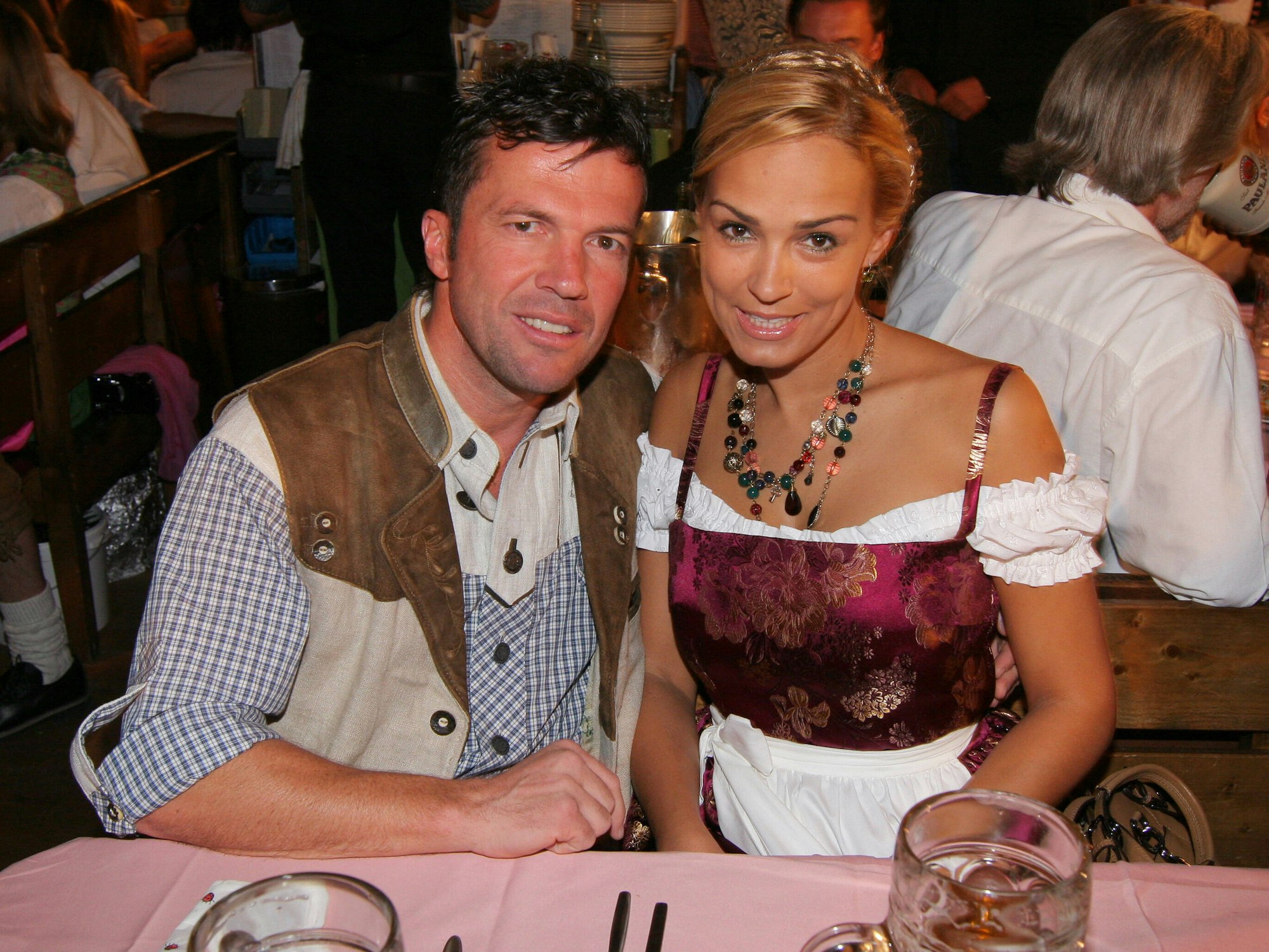 Lothar Matthäus und Frau Marijana sitzen im Festzelt am Tisch, vor ihnen stehen Maßkrüge.