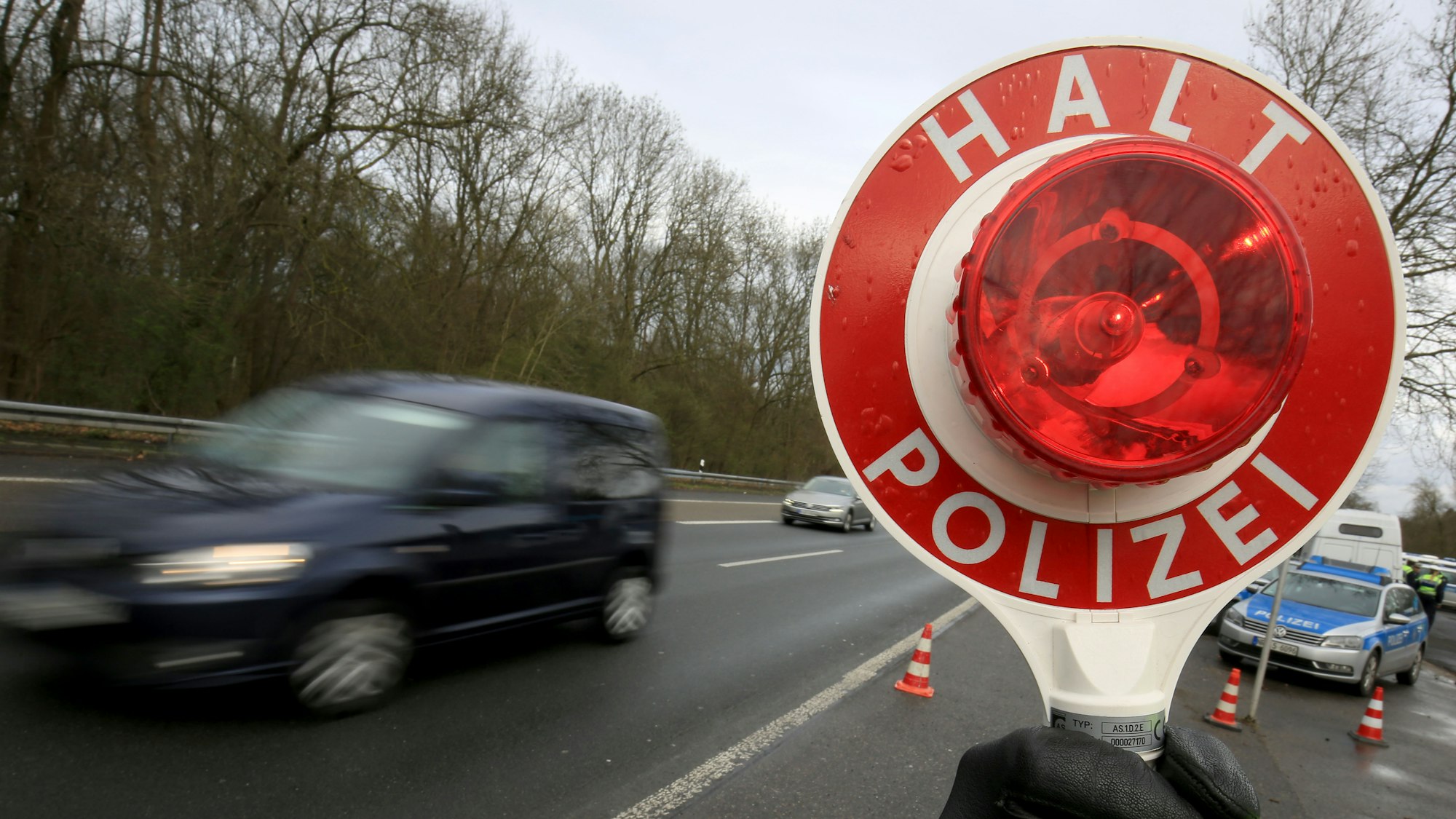 Ein Polizist winkt am 21.03.2017 auf der Autobahn 555 bei Köln (Nordrhein-Westfalen) Fahrzeuge zur Kontrolle raus.