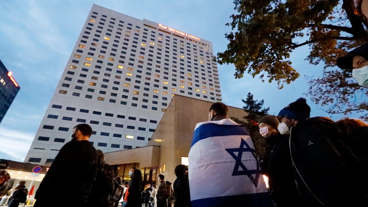 Ein Demonstrant trägt die Fahne Israels über den Schultern. Nach Antisemitismus-Vorwürfen haben sich am Abend Hunderte Menschen vor dem «Westin Hotel» Leipzig versammelt, um Solidarität mit dem Musiker Gil Ofarim und Jüdinnen und Juden in Deutschland zu zeigen.