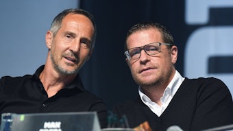 Adi Hütter (l.), Trainer von Borussia Mönchengladbach, ist gemeinsam mit dem ehemaligen Sportdirektor Max Eberl (r.) am 10. August 2021 während der Mitgliederversammlung im Borussia-Park zu sehen. Beide schauen von der Bühne herab in die Kamera des Fotografen.