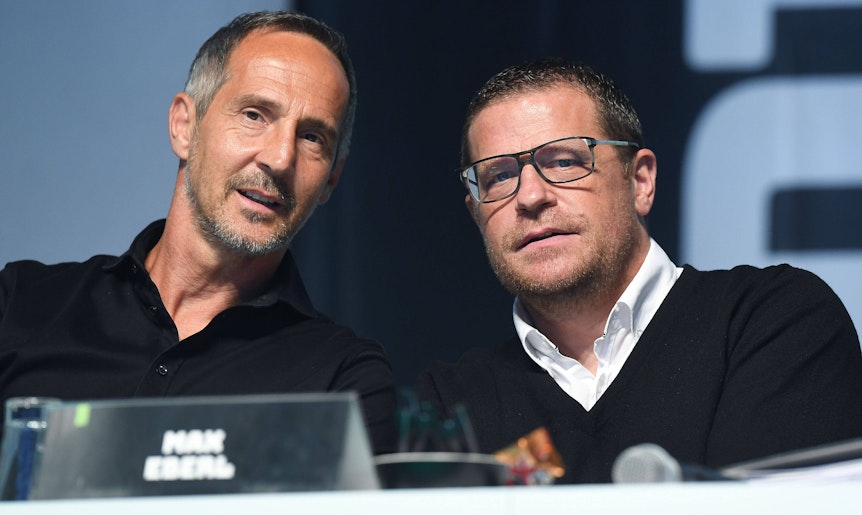 Adi Hütter (l.), Trainer von Borussia Mönchengladbach, ist gemeinsam mit dem ehemaligen Sportdirektor Max Eberl (r.) am 10. August 2021 während der Mitgliederversammlung im Borussia-Park zu sehen. Beide schauen von der Bühne herab in die Kamera des Fotografen.
