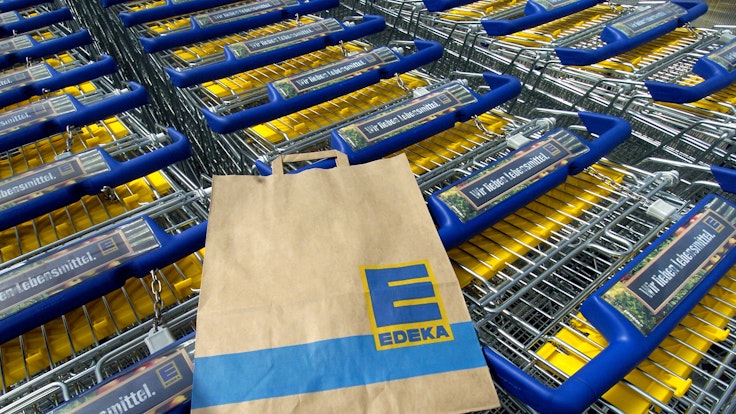 Eine Edeka-Tüte liegt auf einem Einkaufswagen. Die Supermarktkette ruft Sangria zurück. Verkauft wurde das alkoholische Getränk auch in Nordrhein-Westfalen.