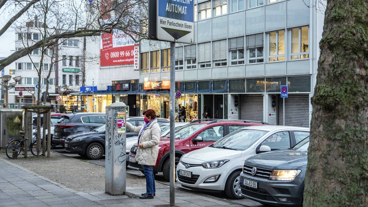 Eine Frau zeiht in Duisburg einen Parkschein.