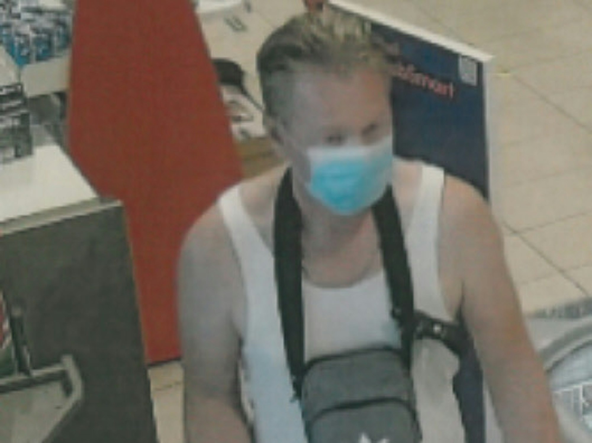 Mann in einem Verkaufsraum mit Mundschutz und Unterhemd