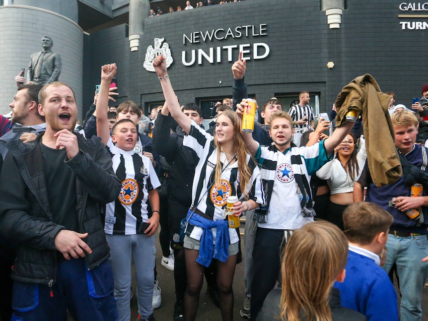 Newcastle-Fans feiern vor dem Stadion und trinken Bier.