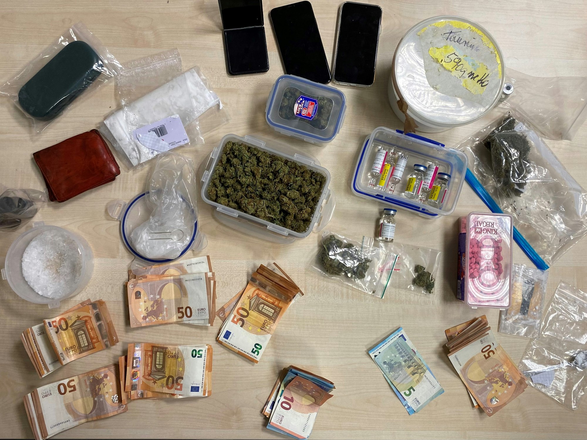 Drogen und Bargeld auf einem Tisch ausgebreitet.