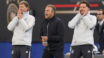 Bundestrainer Hansi Flick (M) sowie die Assistenztrainer Marcus Sorg (l) und Danny Röhl agieren an der Seitenlinie.