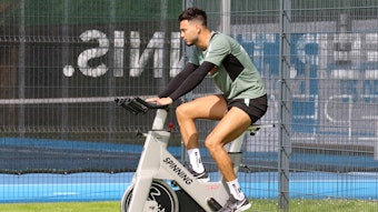 Ramy Bensebaini von Borussia Mönchengladbach sitzt am 18. Juli 2021 auf einem Spinning-Rad während des Trainingslagers in Harsewinkel. Bensebaini schaut nach vorne und radelt.