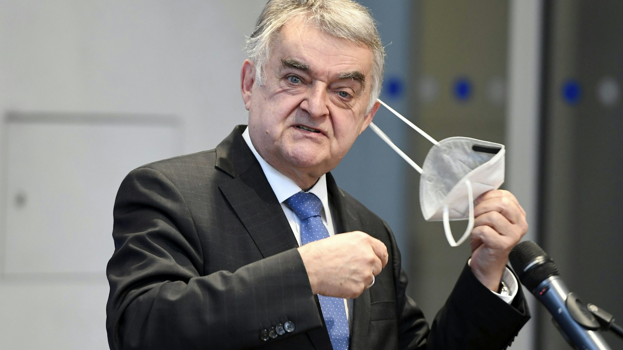 Herbert Reul (CDU), Innenminister von Nordrhein-Westfalen, nimmt seine Maske ab.