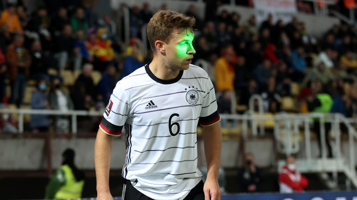 Ein Laserstrahl ist bei Deutschlands Spiel in der WM-Quali in Nordmazedonien genau auf das Gesicht von Joshua Kimmich gerichtet.