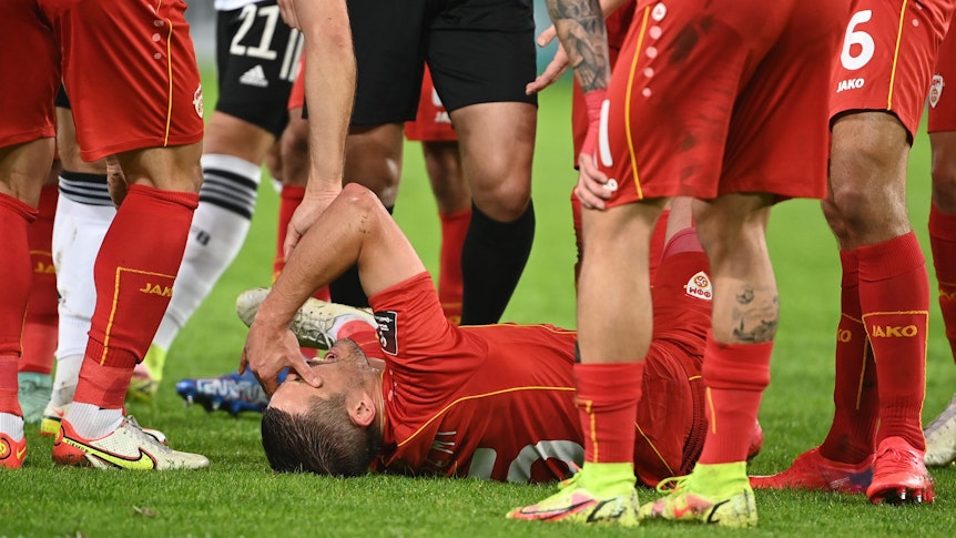 Arijan Ademi liegt nach seiner Verletzung im WM-Quali-Spiel zwischen Nordmazedonien und Deutschland am Boden.