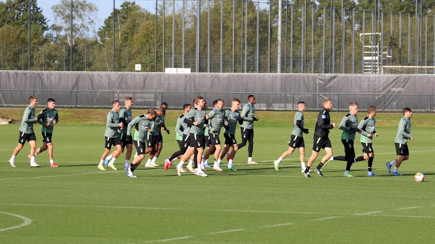 Teile der Mannschaft von Borussia Mönchengladbach laufen sich am 30. September 2021 beim Training am Borussia-Park warm.