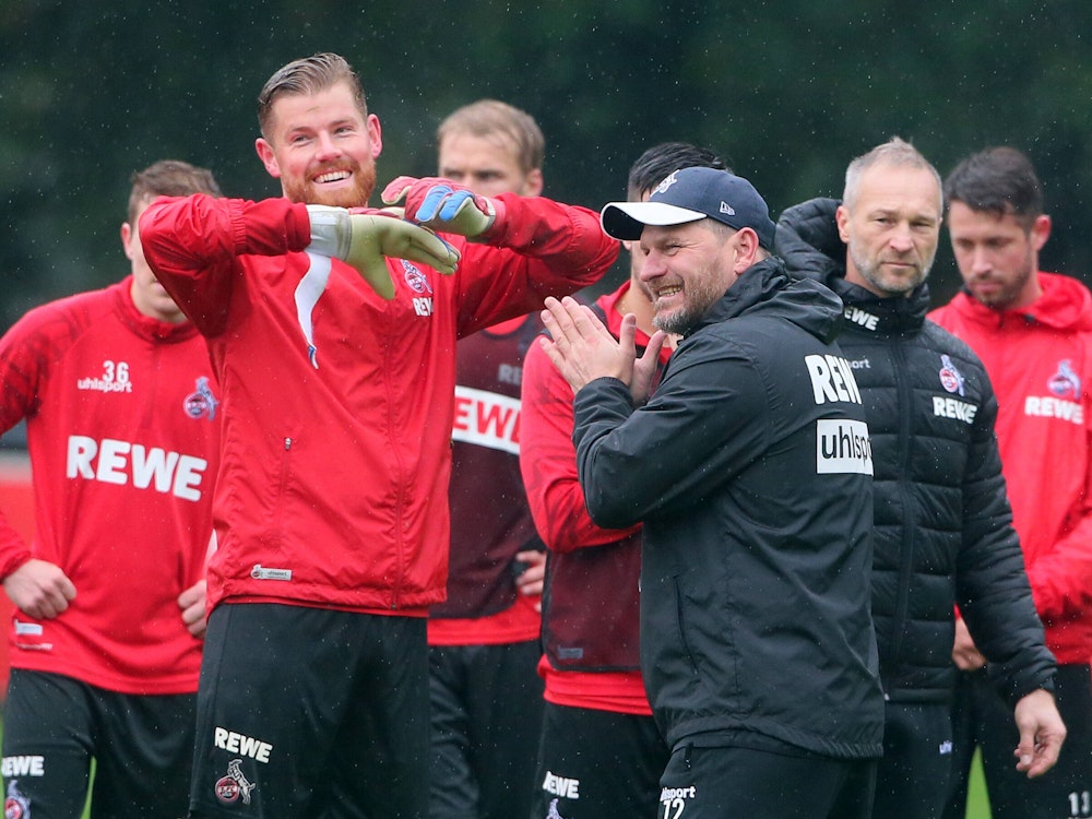 Torwart Timo Horn und Trainer Steffen Baumgart lachen während des Trainings gemeinsam.