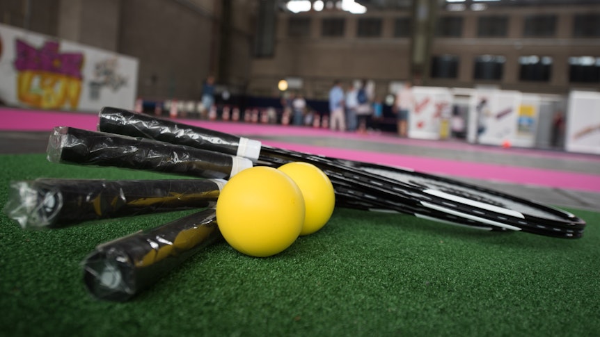 Tennis kann man genauso gut draußen wie drinnen spielen. Auf dem Foto (aufgenommen 27. Juli 2016) sieht man mehrere Tennisschläger und 2 Bälle auf dem Boden liegen.