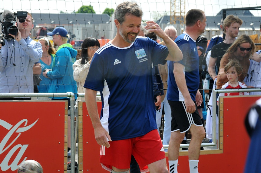 Frederik von Dänemark steht in einem Fußballkäfig. Er trägt ein Fußballtrikot.
