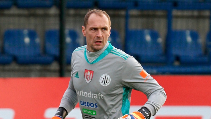 Jaroslav Drobny trägt ein Torwarttrikot samt Torwarthandschuhen.