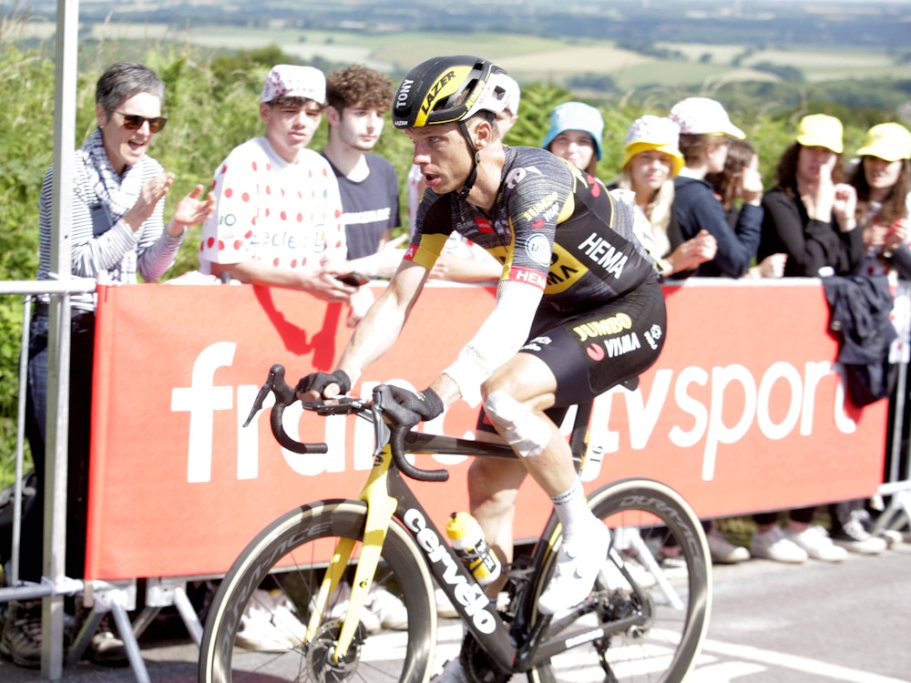 Tony Martin fährt auf seinem Rennrad, sein Arm und sein Bein sind verbunden.