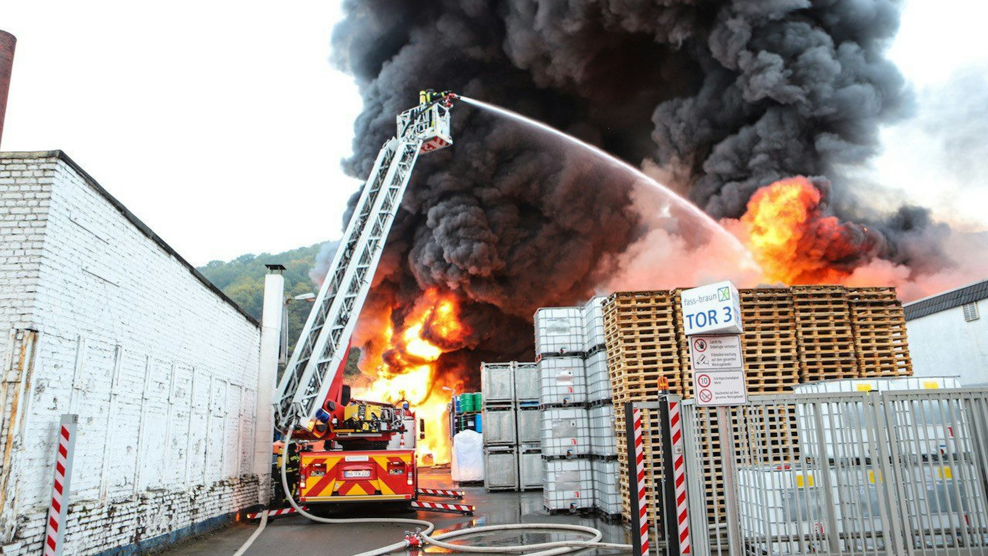Flammen und dichter Rauch schlagen aus einem Firmengebäude.