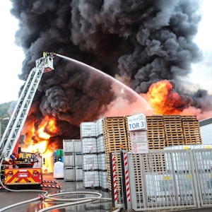Flammen und dichter Rauch schlagen aus einem Firmengebäude.