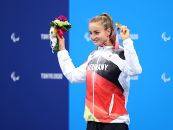 Elena Krawzow präsentiert die Goldmedaille und Sieger-Blumen bei den Paralympics in Tokio.
