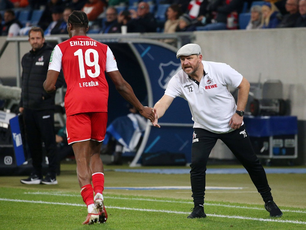 Kingsley Ehizibue klatscht beim Bundesliga-Spiel TSG Hoffenheim gegen 1. FC Köln mit Steffen Baumgart ab.