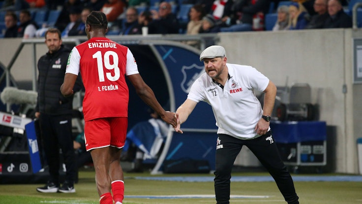 Kingsley Ehizibue klatscht beim Bundesliga-Spiel TSG Hoffenheim gegen 1. FC Köln mit Steffen Baumgart ab.