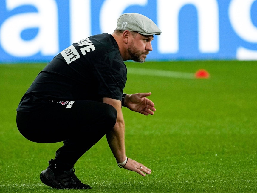 Steffen Baumgart streichelt den Rasen vor dem Spiel TSG Hoffenheim gegen 1. FC Köln.