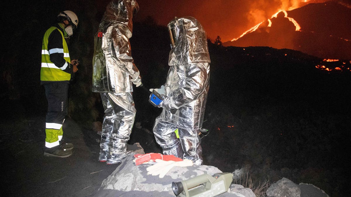 In der Flammenhölle untersuchen Mitarbeiter der Militärischen Nothilfeeinheit in Spezialanzügen die Lava.