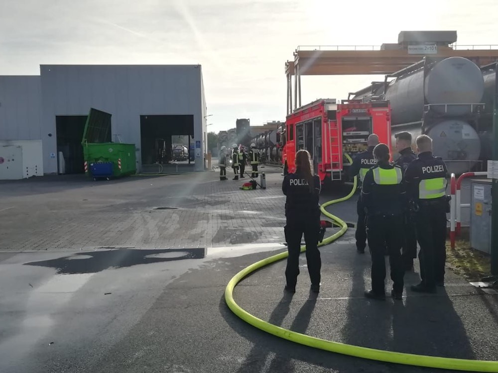 Feuerwehr- und Polizeikräfte stehen in einem Industriegebiet in Köln-Rondorf.