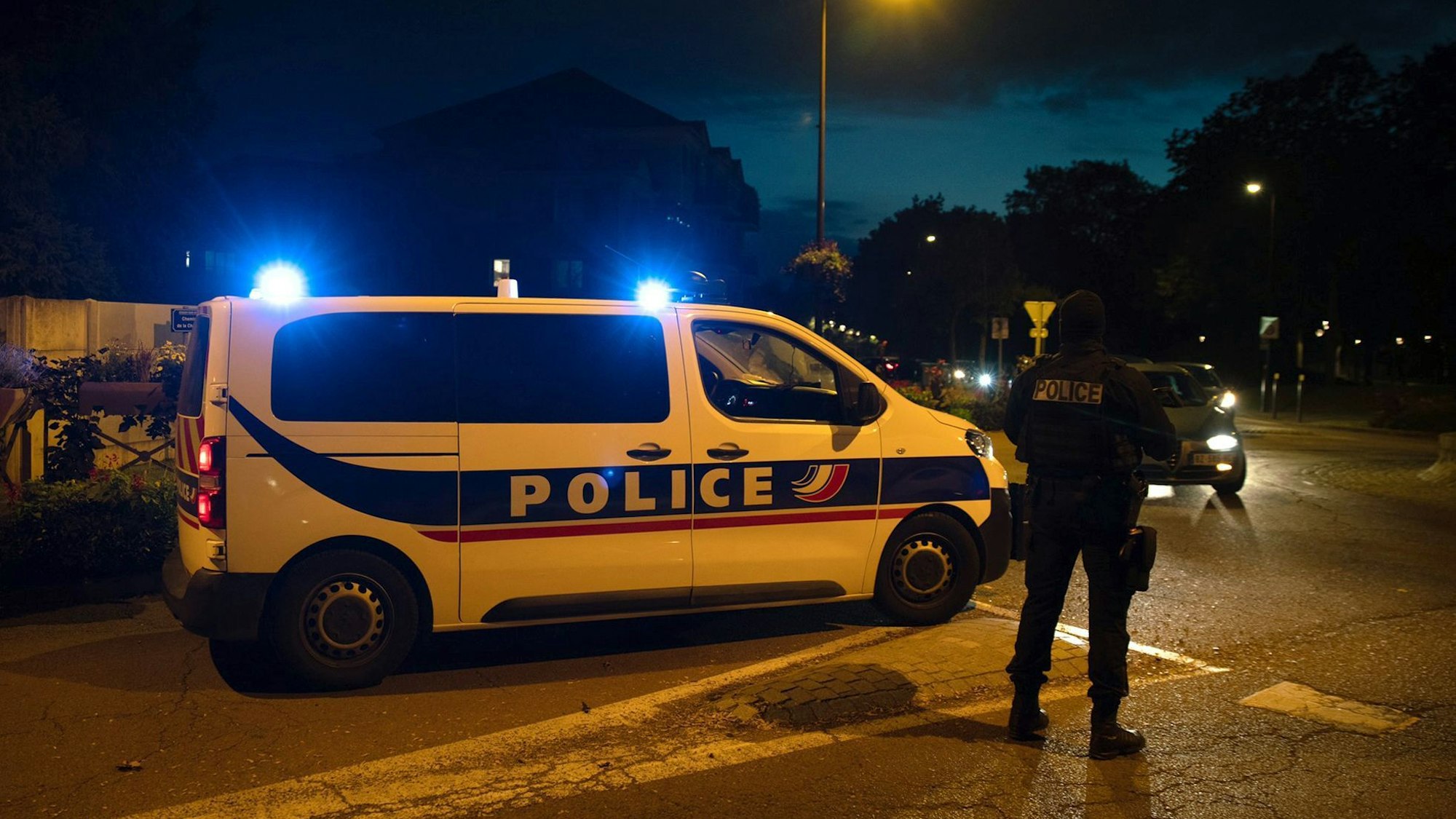 Ein Polizist steht neben einem Einsatzwagen an einem Tatort in der Nähe von Paris, aufgenommen im Oktober 2020.